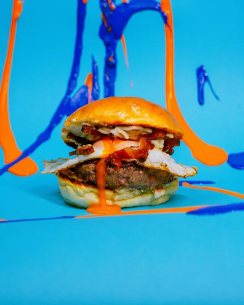 Burger tra schizzi di colore azzurro